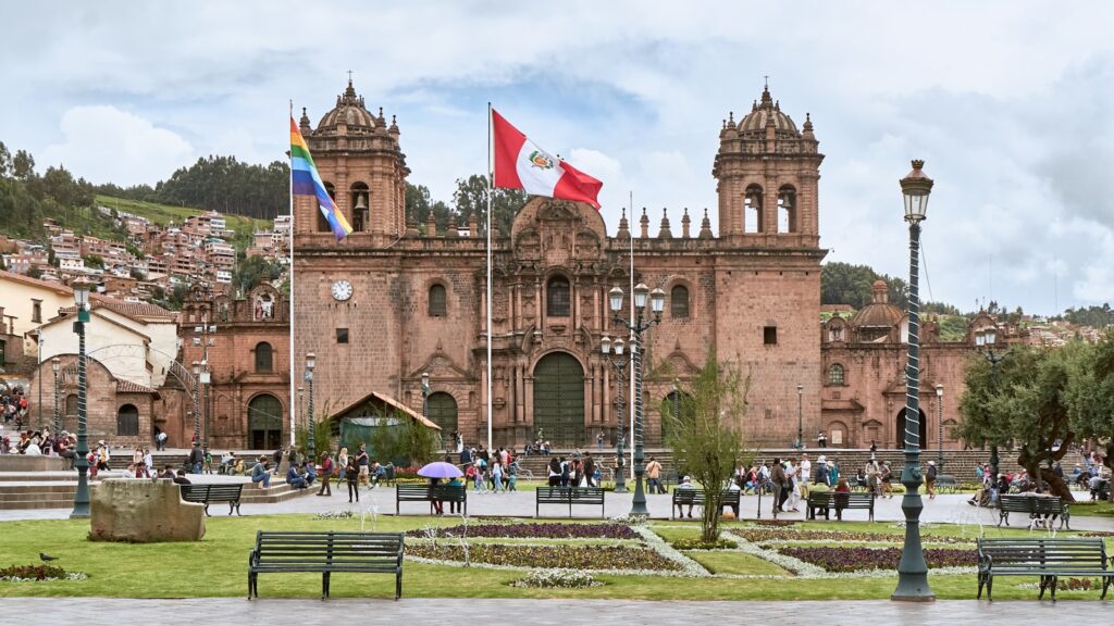 people walking near Cusco Cathedral in Peru under white and blue sky